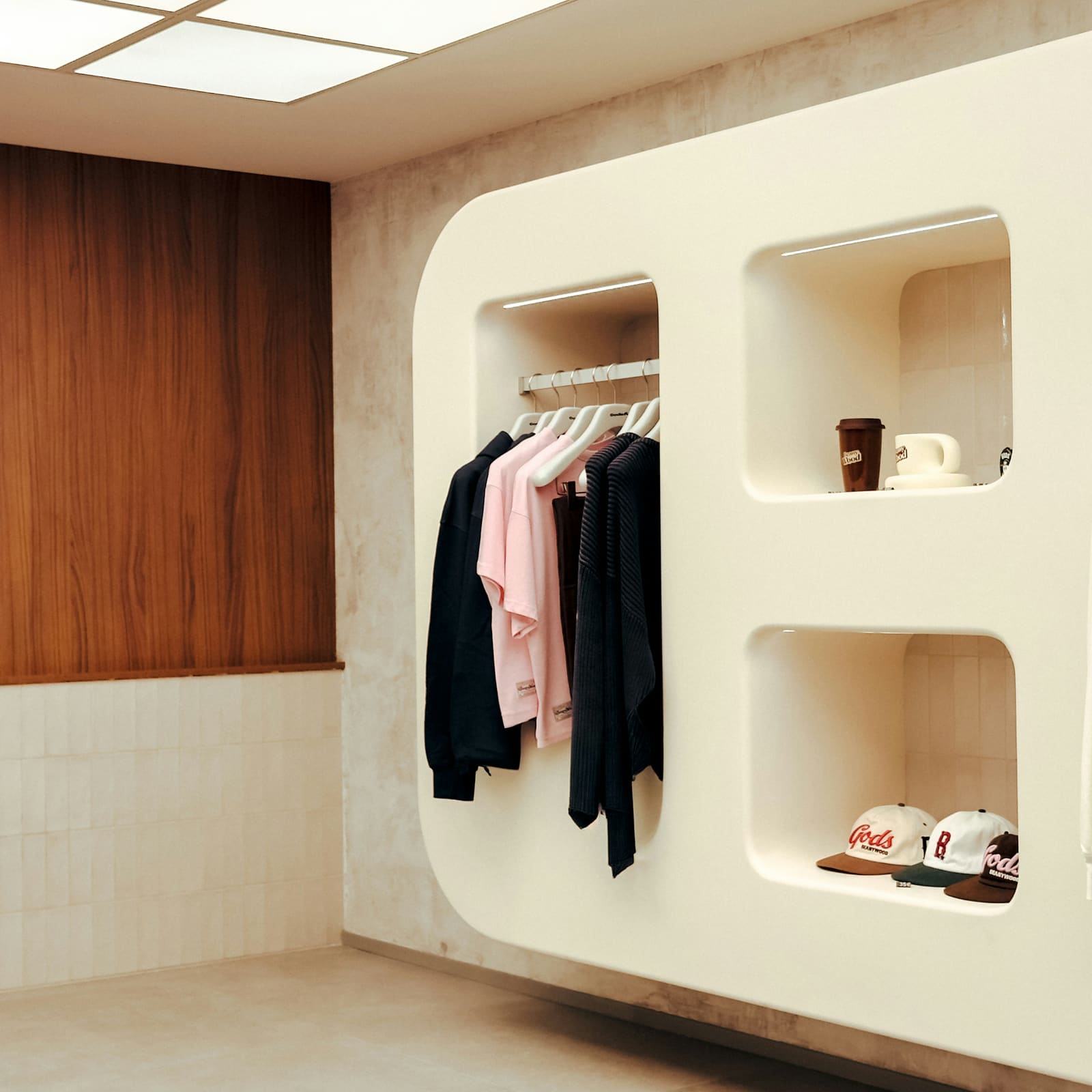 Modern retail store interior with sculpted white fixture millwork, a clothing rack, and built-in display niches